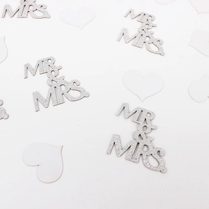 Detail of silver glitter MR & MRS wedding confetti with decorative white heart cutouts