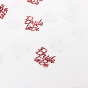 Sparkling red Bride to Be confetti and white heart-shaped cutouts for hen party decor