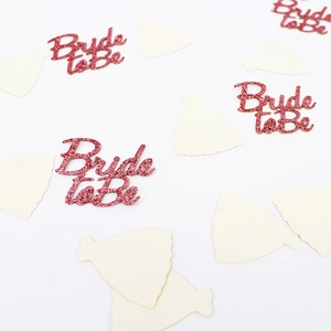 Macro of pink glitter Bride to Be letters and ivory wedding dress paper confetti