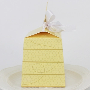 Yellow honeycomb pattern party favor box with white silk ribbon bow for baby birthdays