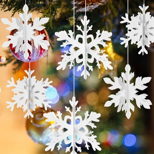 3D white paper snowflake ornaments hanging with warm festive Christmas tree bokeh background