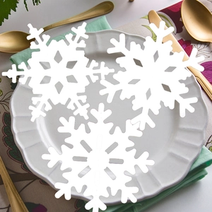Three pieces of white snowflake table decorations in a festive winter dinner setting