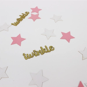 Macro detail of gold twinkle lettering and multi-color star confetti for party decor