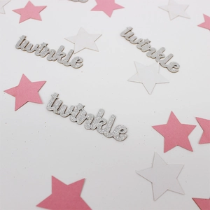 Macro shot of silver glitter twinkle letters and star confetti for baby shower party decor