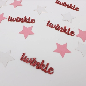 Close-up of red glitter twinkle script and pink star confetti for party table decor