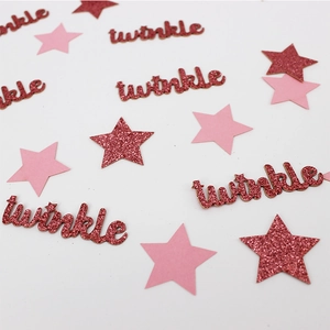 Macro shot of pink paper stars and red glitter twinkle confetti for party table decor