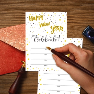 Einladungskarten für die Neujahrsparty mit goldener Schrift und Umschlägen auf Holz