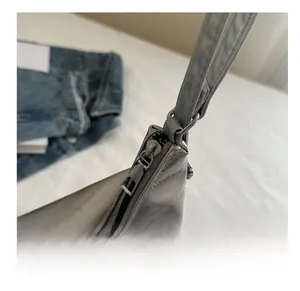 Detailed close-up of smooth metal zipper and silver faux leather shoulder bag strap