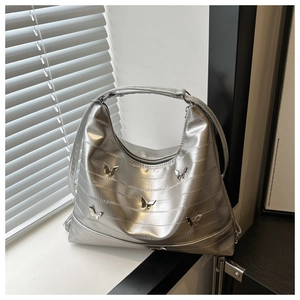 Detail of silver metallic leather tote with 3D butterfly accents and Y2K pleats