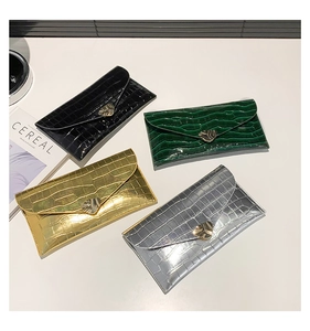 Vue détaillée de quatre sacs enveloppes à motif crocodile avec fermoirs en métal cœur
