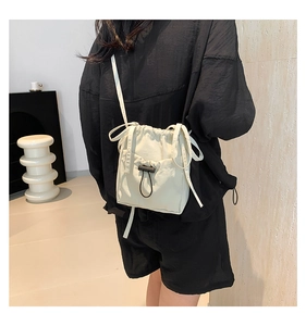 Detail showing the adjustable drawstring closure and nylon fabric texture of the crossbody bag