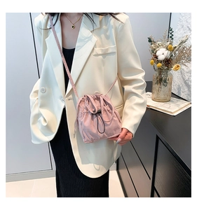 Détail du sac seau en nylon rose avec fermeture à cordon et texture plissée