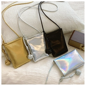 Detail of colorful mini crossbody phone bags with textured finish and woven ball knots