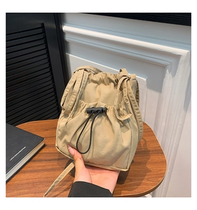 Détail du sac seau en nylon kaki montrant le cordon de serrage et la boucle noire