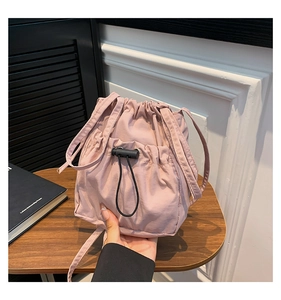 Vue détaillée du sac seau rose en nylon froncé avec cordon et bandoulière réglable