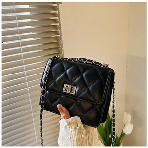 Dettaglio mini borsa trapuntata nera con catena argentata e chiusura a girello