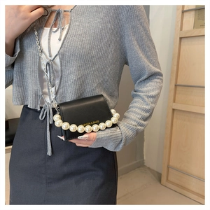 Mini black leather crossbody bag with oversized pearl handle and fashion gold text