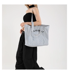 Détail du sac cabas en toile à rayures bleues et blanches avec texte summer et anses
