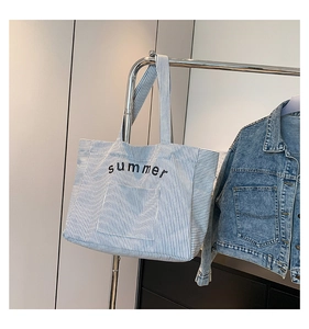 Détail d'un sac cabas en toile rayé bleu et blanc avec inscription summer en noir