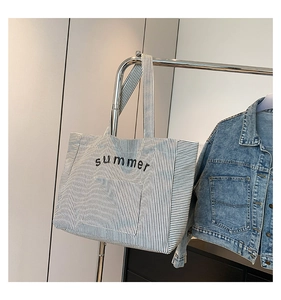 Gros plan d'un sac cabas en toile rayée avec imprimé été suspendu pour un look décontracté