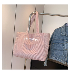 Détail du sac fourre-tout en toile à rayures rouges et blanches avec imprimé sur la poche