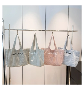 Détail de sacs cabas en toile rayée vert, rose et bleu avec broderie summer de grande capacité