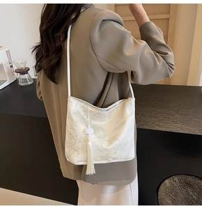 Detail of white brocade bucket bag with bamboo embroidery and elegant jade tassel