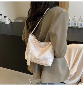 Detail of elegant brocade shoulder bag with traditional embroidery and white tassel