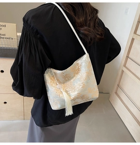 Detailed close-up of a Chinese jacquard shoulder bag with tassel and floral embroidery