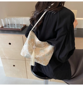 Detail of embroidered jacquard pattern and long white tassel on this retro bucket bag
