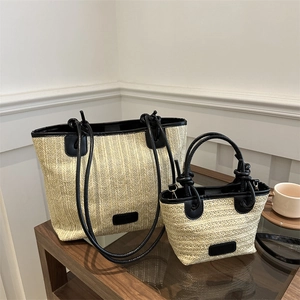 Juego de bolsos de paja tejida con adornos de cuero negro en un entorno informal