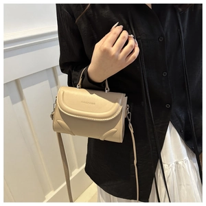 Detail der cremefarbenen Umhängetasche mit Griff und dem Fashion & Bag Schriftzug