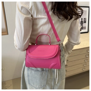 Fuchsiafarbene matte Ledertasche mit Logo, getragen von einem Model in modernem Interieur