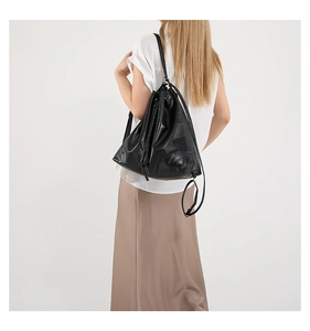 Detail of black drawstring bucket bag with soft textured leather and drawstring closure