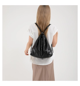 Detail view of a black drawstring bucket bag with a quilted square pattern design