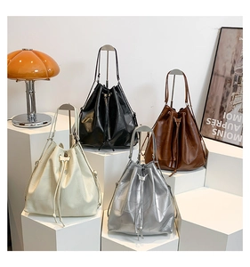 Four colors of drawstring bucket bags with patchwork texture on geometric display bases