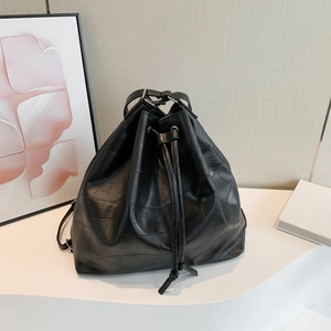 Minimalist black leather patchwork tote with geometric texture and silver metal rings