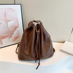 Brown leather patchwork bucket bag with drawstring closure and vintage minimalist style