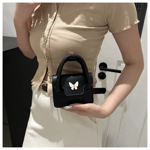 Detail shot of mini black handbag with white butterfly accent and gold chain strap