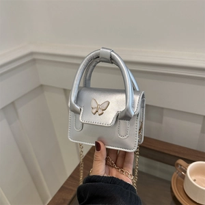 Silver ballet-style mini handbag featuring a metallic butterfly clasp and chain strap