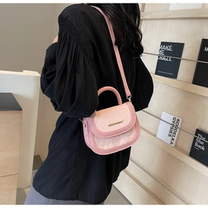 Side view of a pink marble texture saddle bag with gold metal buckle on a model