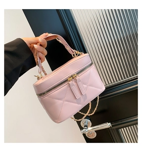Close-up of pink quilted mini bucket bag with gold zipper and metal chain strap
