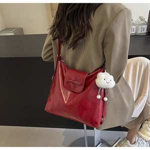 Red leather backpack with bow detail and cloud charm shown on a model in profile
