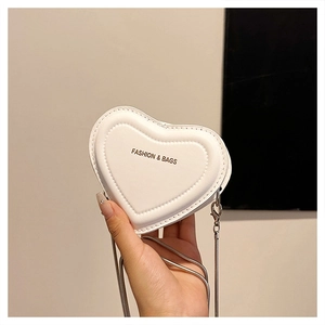 Close-up of heart-shaped white PU leather bag with silver chain and stitched details