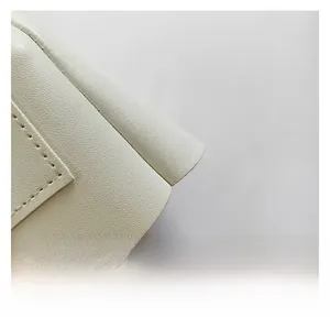 Detail of cream leather texture with high-quality stitching on a chain shoulder bag