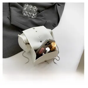 Internal view of a small white leather bag showing storage for phone and cosmetics