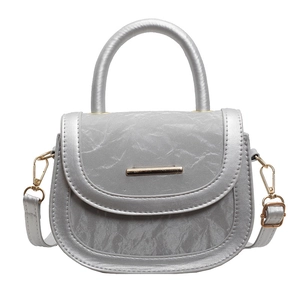 Silver textured leather saddle bag with gold metal hardware and top circular handle