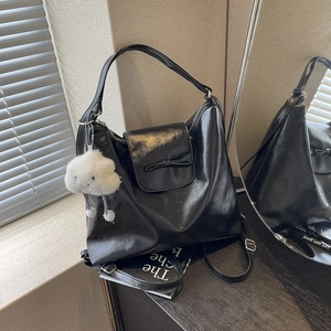 Minimalist black PU leather tote bag with a decorative bow and white plush cloud charm