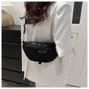 Détail du sac bandoulière noir avec strass scintillants et étiquette de mode stylée