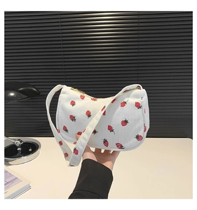 Détail du sac bandoulière en velours blanc à imprimé fraises et fermeture éclair dorée